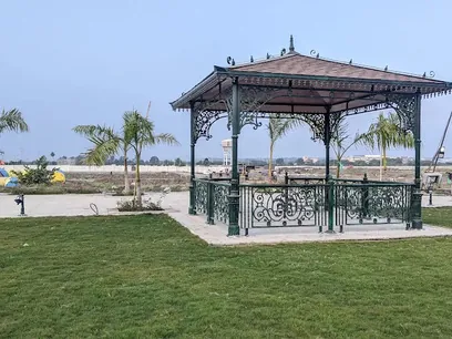 Wrought-iron gazebo on a landscaped lawn at Siddhi Olympia (actual photo)